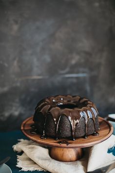 a bundt cake with chocolate icing on a wooden plate