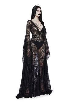 you’re a Victorian splendor in the shadows. This maxi dress has a lace construction, a v-neckline with chain detail and dangling cross charm, long floor-length flare sleeves, and side zipper closure. Gothic Black Dress Long, Black Gothic Long Dress, Black Lace Gothic Dress, Black Gothic Dress Long, Goth White Dress, Long Lace Black Dress, Goth Dress Outfit, Black Lace Dress With Sleeves, Gothic Dress Elegant