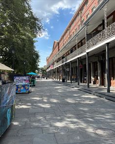 an empty city street lined with shops and stores on both sides, under a partly cloudy blue sky