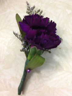 a purple flower on a white surface