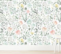 a wall with flowers and leaves painted on it in pastel colors, against a white background