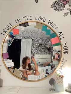 a mirror that has some writing on it and a girl in the reflection with her hand up to her face