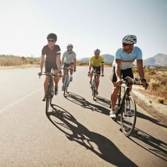 five people riding bikes down the road