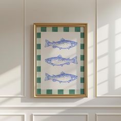 two fish are hanging on the wall in front of a white fireplace with green and white checkered flooring