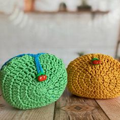 two small crocheted purses sitting on top of a wooden table next to each other