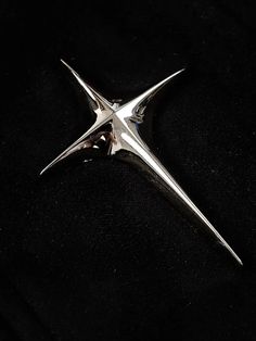 a silver star brooch sitting on top of a black cloth