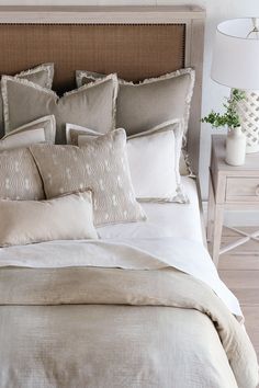 a bed with white linens and pillows on it