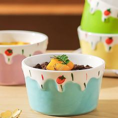 three bowls filled with food sitting on top of a wooden table next to spoons