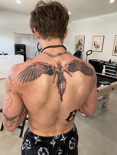 the back of a man with tattoos on his body