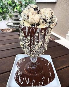 an ice cream sundae on a plate with chocolate sauce drizzled over it