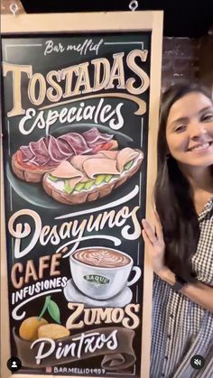 a woman standing next to a sign with food on it