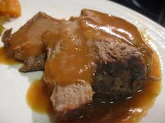 a white plate topped with meat and gravy