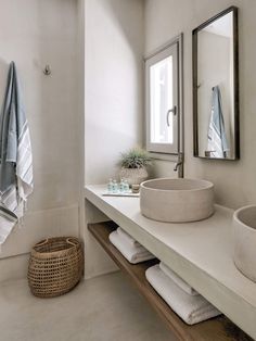 a white bathroom with two sinks and towels on the counter next to eachother