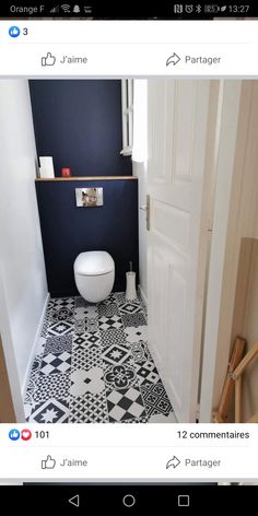 a white toilet sitting inside of a bathroom next to a doorway with a black and white tiled floor