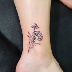 a small flower tattoo on the ankle