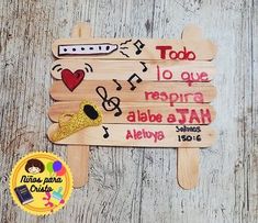 a wooden sign with musical notes on it and a gold medal next to it that says, too do i que respira albia atah