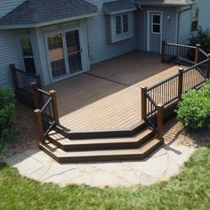 a deck with steps and railings in front of a house