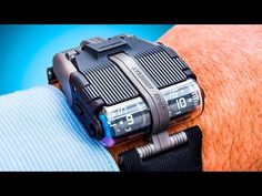 a close up of a wrist with a watch on it's arm and an electronic device attached to the wrist