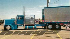 a blue semi truck parked in a parking lot