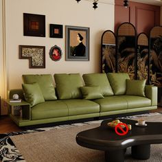 a living room with green couches and pictures on the wall above them, along with a coffee table