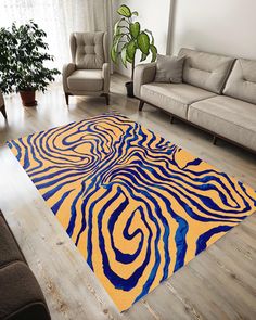 a living room area with couches, chairs and a rug on the wooden floor