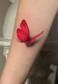 a red butterfly tattoo on the arm