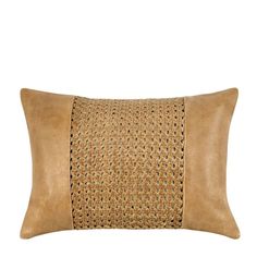 a tan leather pillow with an intricate design on the front and side, along with a brown