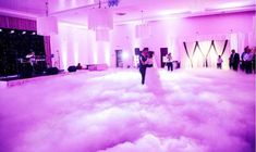 a bride and groom are dancing in the middle of a cloud filled dance floor at their wedding reception