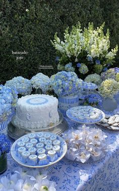 a table topped with blue and white cupcakes