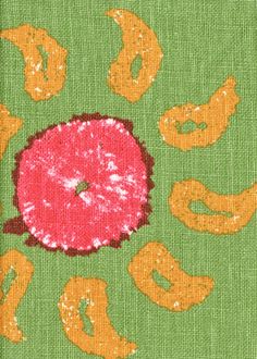 an orange and pink donut on green fabric with the word o's spelled out