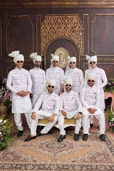 a group of men dressed in white poses for a photo