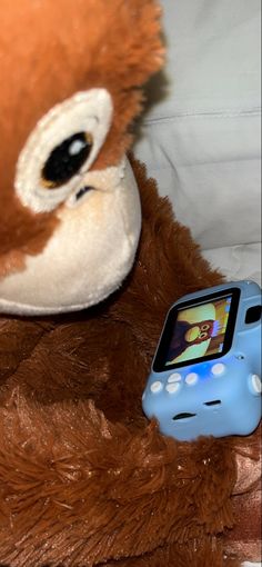 a stuffed animal is next to a cell phone