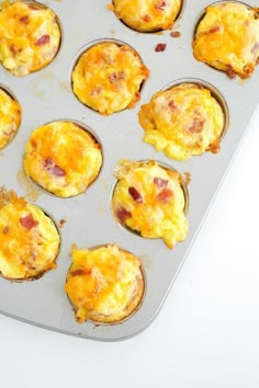 muffin tins filled with breakfast food on top of a white counter