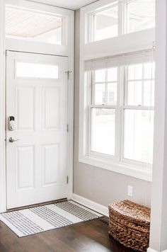 a white door with two windows and a basket on the floor in front of it