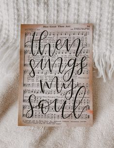 an old book with the words when songs are soul written on it, laying on top of a white blanket