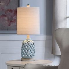 a table with a lamp on it next to a chair