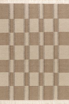 a brown and white checkered rug with fringes