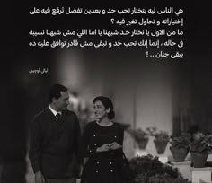 two people standing next to each other in front of a black and white photo with an arabic quote