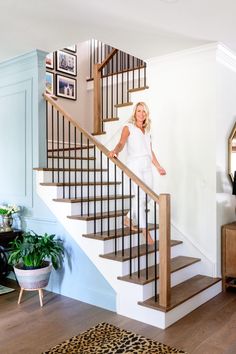 a woman is standing on the stairs in her living room and posing for a photo