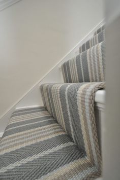 the stairs are lined with gray and white striped rugs