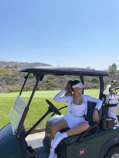 a woman sitting on the back of a golf cart