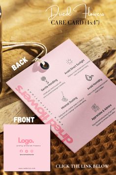 a pink business card sitting on top of a wooden table