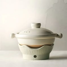 a white ceramic covered dish sitting on top of a table