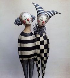 two creepy clowns are standing next to each other with their heads turned upside down