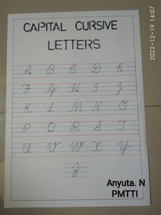 the capital cursive letters are lined up on top of a sheet of paper