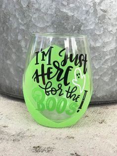 a green stemless wine glass that says i'm just here for the boos