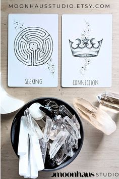 two cards sitting on top of a wooden table next to ice crystals and spoons