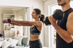 a man and woman doing exercises with dumbbells