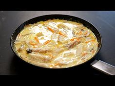 a skillet filled with food sitting on top of a table next to a knife