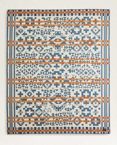 an orange, blue and white rug with geometric designs on it's edges is shown